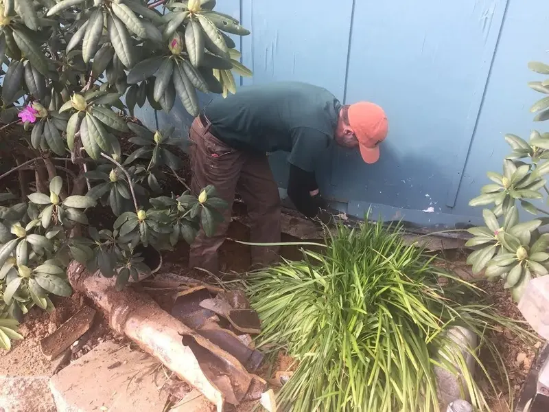 Technician working on a line beside a building wall