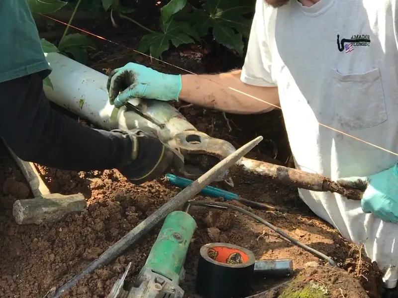 Two techs fitting a pipe joint by hand