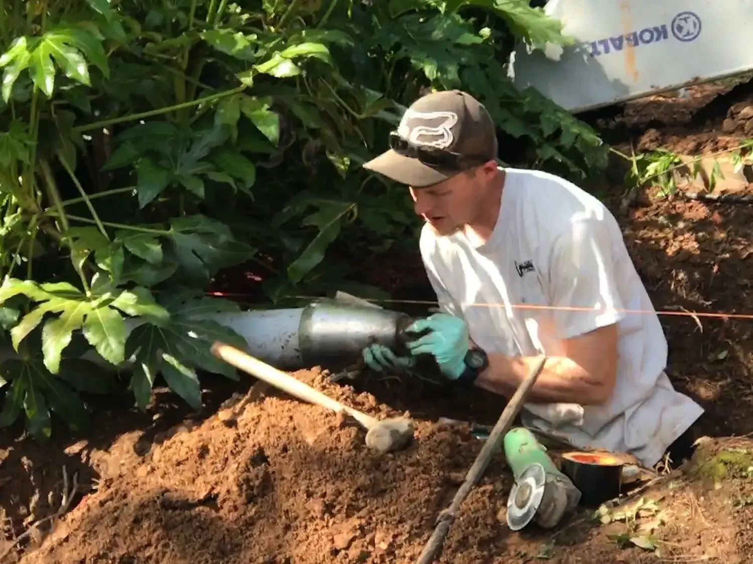 Technician fitting a new drain line by hand